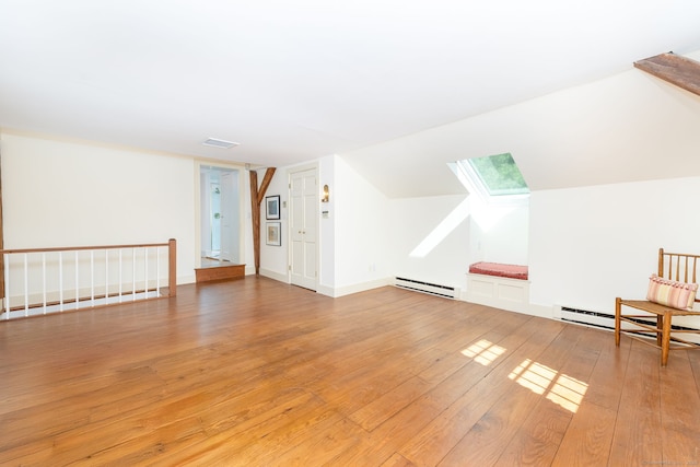 bonus room featuring light wood-style floors, a baseboard heating unit, visible vents, and a skylight