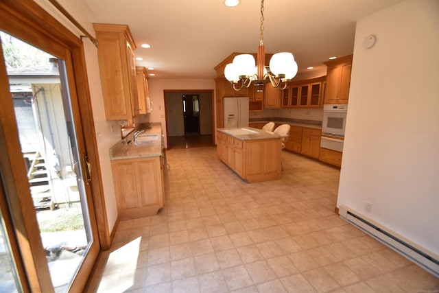 kitchen with white appliances, a baseboard heating unit, a sink, a warming drawer, and a notable chandelier