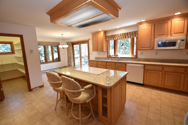 kitchen featuring an inviting chandelier, baseboard heating, white appliances, recessed lighting, and a kitchen island