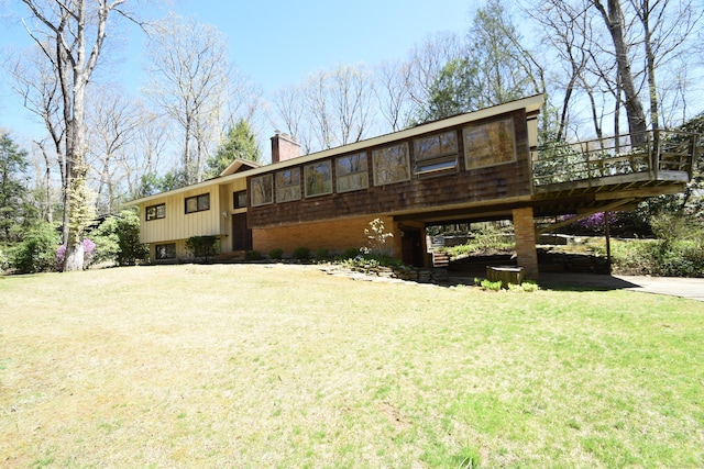 rear view of property with a lawn, a wooden deck, and a chimney