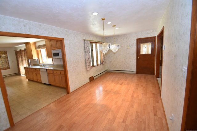 kitchen featuring a notable chandelier, white appliances, light countertops, light wood-style flooring, and a baseboard heating unit