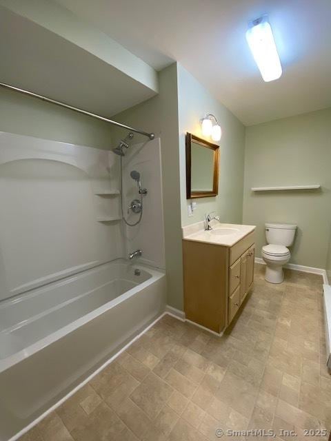 bathroom featuring vanity, baseboards, tub / shower combination, and toilet