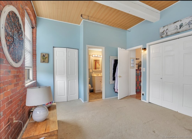 bedroom with connected bathroom, baseboards, carpet floors, and wood ceiling