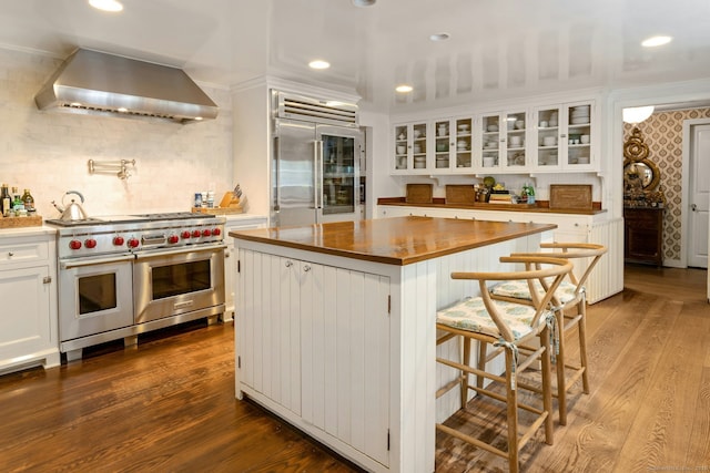 35 Old Redding Rd, Easton, CT 06612 - kitchen featuring premium appliances, wall chimney exhaust hood, wood counters, white cabinets, and glass insert cabinets