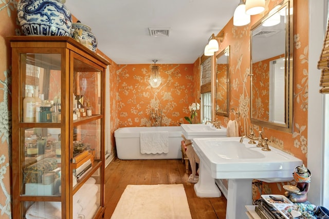 35 Old Redding Rd, Easton, CT 06612 - bathroom with wallpapered walls, wood-type flooring, a freestanding tub, and a sink