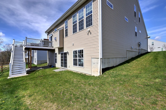 back of property with a lawn, a wooden deck, and stairway