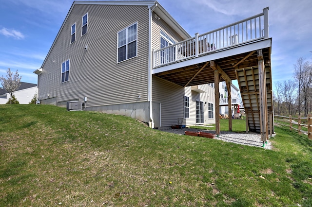view of side of home with a deck, central air condition unit, fence, stairway, and a yard