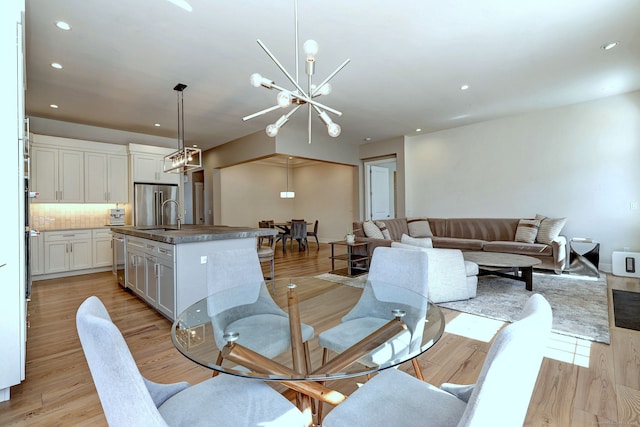 dining space featuring a chandelier, recessed lighting, and light wood-style floors