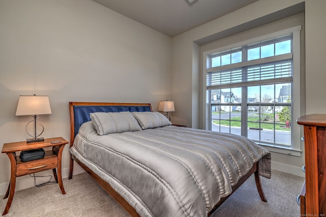 bedroom featuring baseboards and light colored carpet