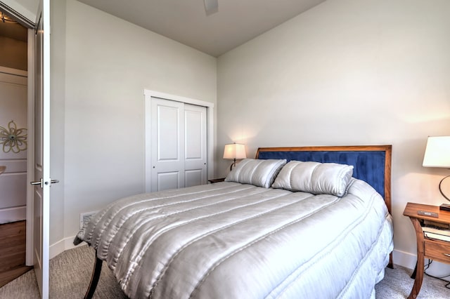 carpeted bedroom featuring a closet, lofted ceiling, and baseboards