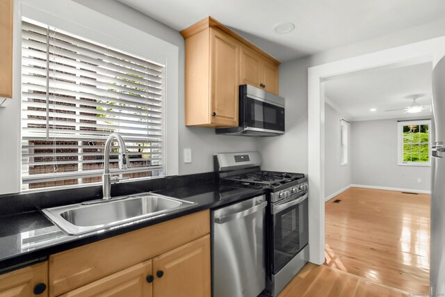61 Longview Ave, Fairfield, CT 06824 - kitchen featuring dark countertops, a sink, light wood finished floors, light brown cabinets, and stainless steel appliances