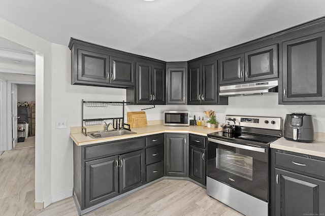 6 Beech St, Bristol, CT 06010 - kitchen featuring light countertops, under cabinet range hood, a sink, light wood finished floors, and stainless steel appliances