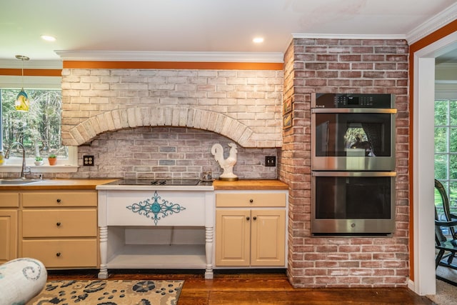 kitchen featuring ornamental molding, dark wood-style flooring, stainless steel double oven, black electric cooktop, and a sink
