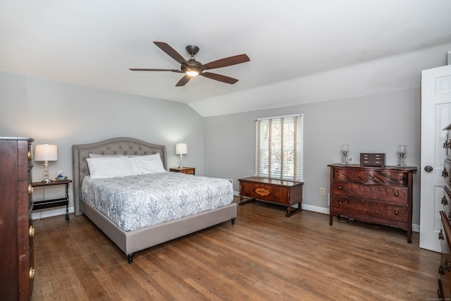 bedroom featuring baseboards, ceiling fan, vaulted ceiling, and wood finished floors
