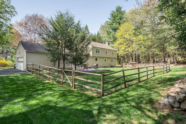view of yard with fence and a garage