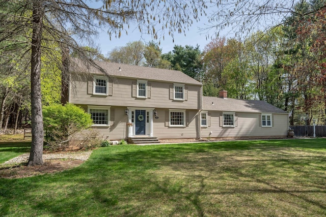 colonial home with a chimney and a front lawn