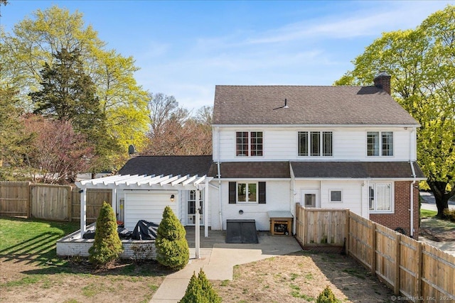 rear view of property with a chimney, a fenced backyard, a patio, roof with shingles, and a pergola