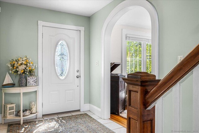foyer with light tile patterned floors and arched walkways