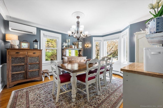 dining room with a baseboard radiator, an inviting chandelier, light wood finished floors, ornamental molding, and a wall mounted AC