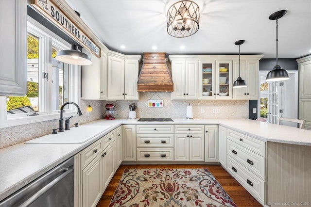kitchen featuring a healthy amount of sunlight, stainless steel dishwasher, custom range hood, a sink, and a peninsula