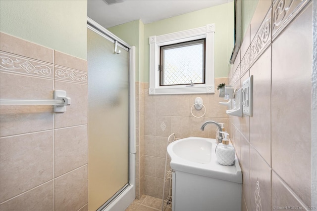 full bath with tile walls, a wainscoted wall, and a shower stall