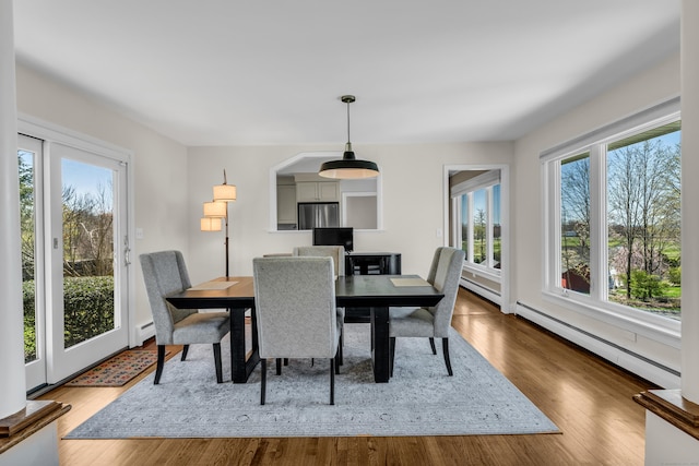 dining area featuring a baseboard heating unit, wood finished floors, and a baseboard radiator