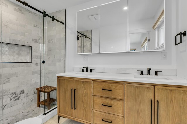 full bath with a sink, a stall shower, and double vanity