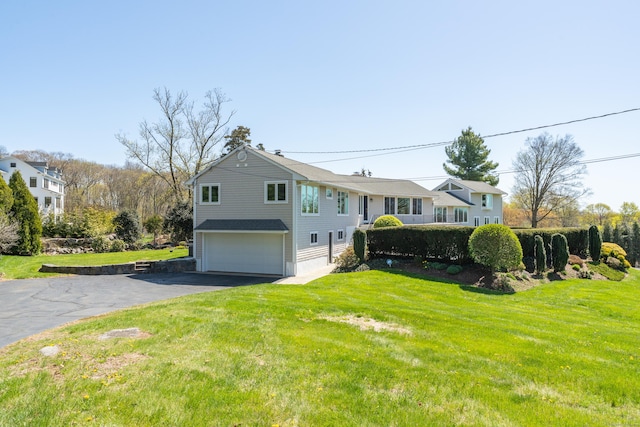 exterior space with an attached garage, driveway, and a front lawn