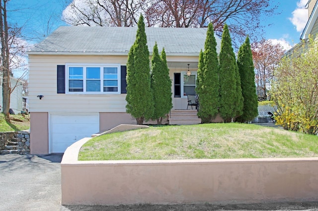 view of front of home with driveway, covered porch, a front yard, and an attached garage