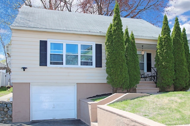 single story home with a porch, a shingled roof, and an attached garage