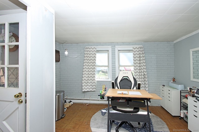 home office with a baseboard heating unit and brick wall
