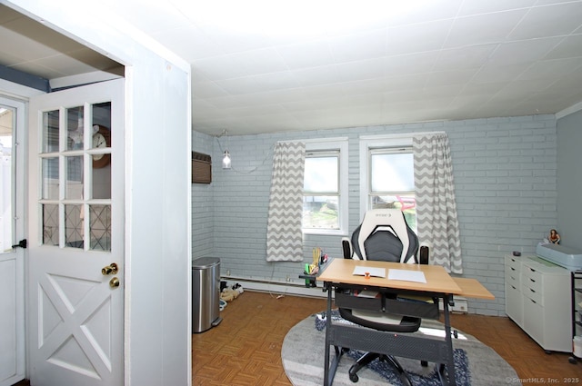 office area with brick wall and a baseboard heating unit