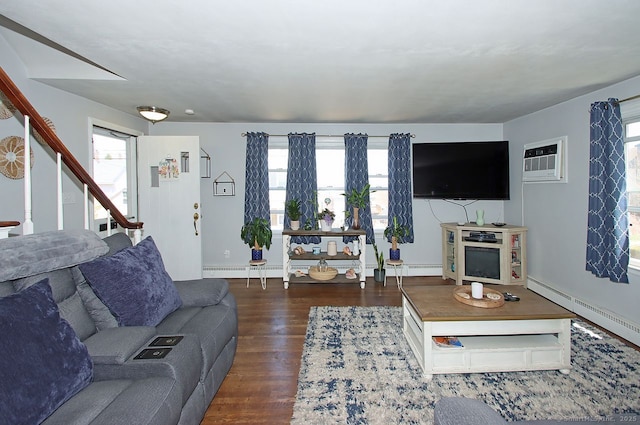 living room with a wealth of natural light, a baseboard radiator, and an AC wall unit