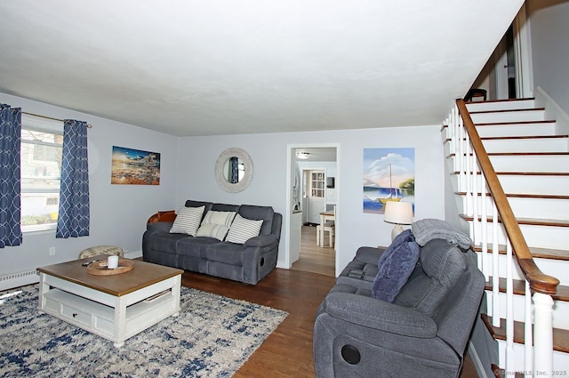 living room with wood finished floors, baseboards, baseboard heating, and stairs