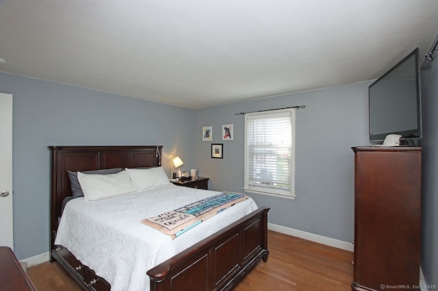 bedroom featuring wood finished floors and baseboards