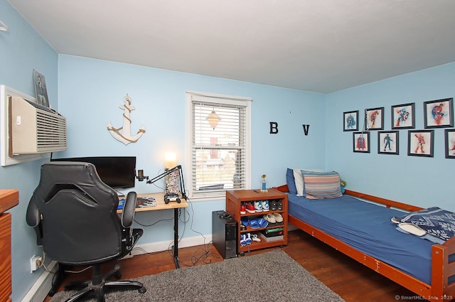 bedroom with baseboards, wood finished floors, and a baseboard heating unit