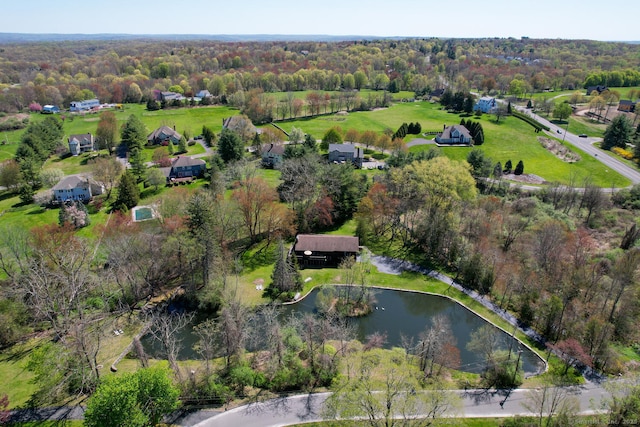 birds eye view of property with a water view and a wooded view