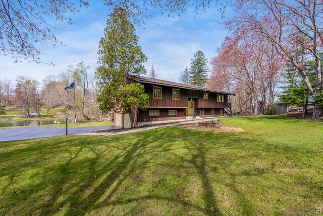 rear view of house with a yard and a water view