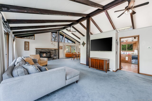 carpeted living room featuring a healthy amount of sunlight, baseboards, ceiling fan, and a fireplace