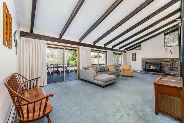 carpeted living area featuring a stone fireplace, a wealth of natural light, high vaulted ceiling, and beamed ceiling