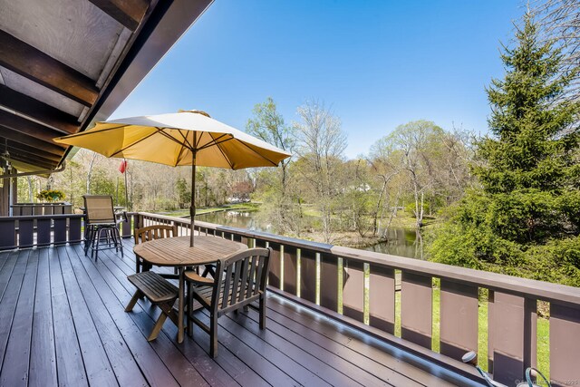 deck featuring a water view and outdoor dining space