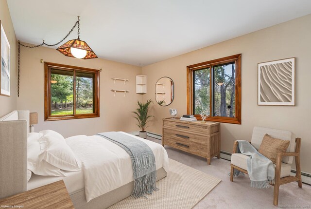 bedroom with light colored carpet, a baseboard radiator, baseboard heating, and multiple windows