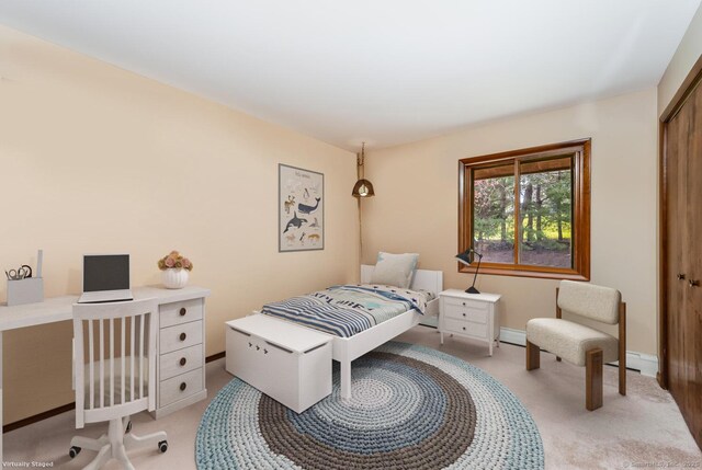 bedroom with a closet, light carpet, and a baseboard radiator