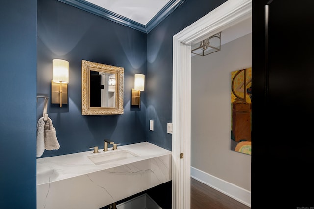 bathroom featuring a sink, wood finished floors, and baseboards