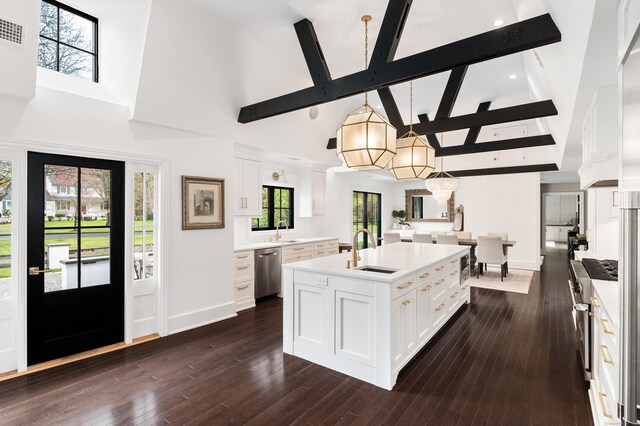 kitchen with white cabinetry, high vaulted ceiling, stainless steel dishwasher, and a sink