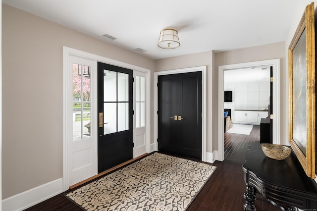 entrance foyer with dark wood-type flooring, visible vents, plenty of natural light, and baseboards