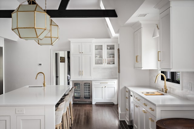 kitchen with wine cooler, a sink, light countertops, and tasteful backsplash