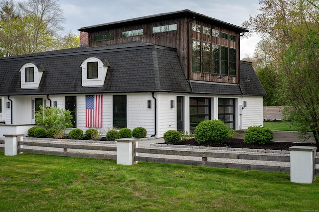 view of front of house featuring roof with shingles and a front lawn