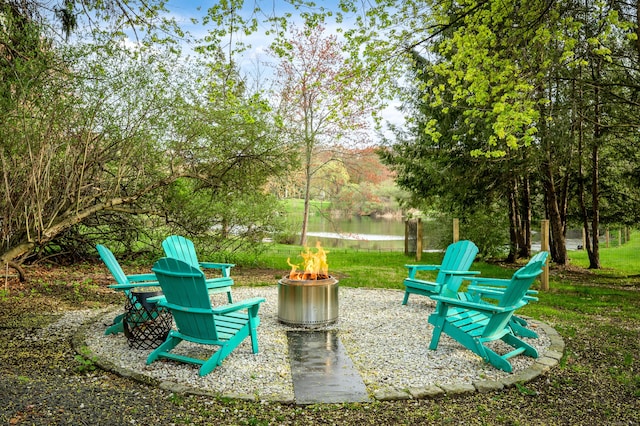 view of property's community with a water view and an outdoor fire pit