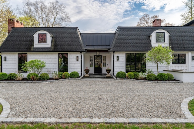 view of front of property with a shingled roof and a chimney